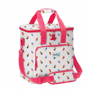 White Swig-branded insulated cooler bag with pink handles and shoulder strap, covered in a repeating pattern of small colorful rainbow frozen pops on sticks, featuring a front zippered pocket with the Swig logo.